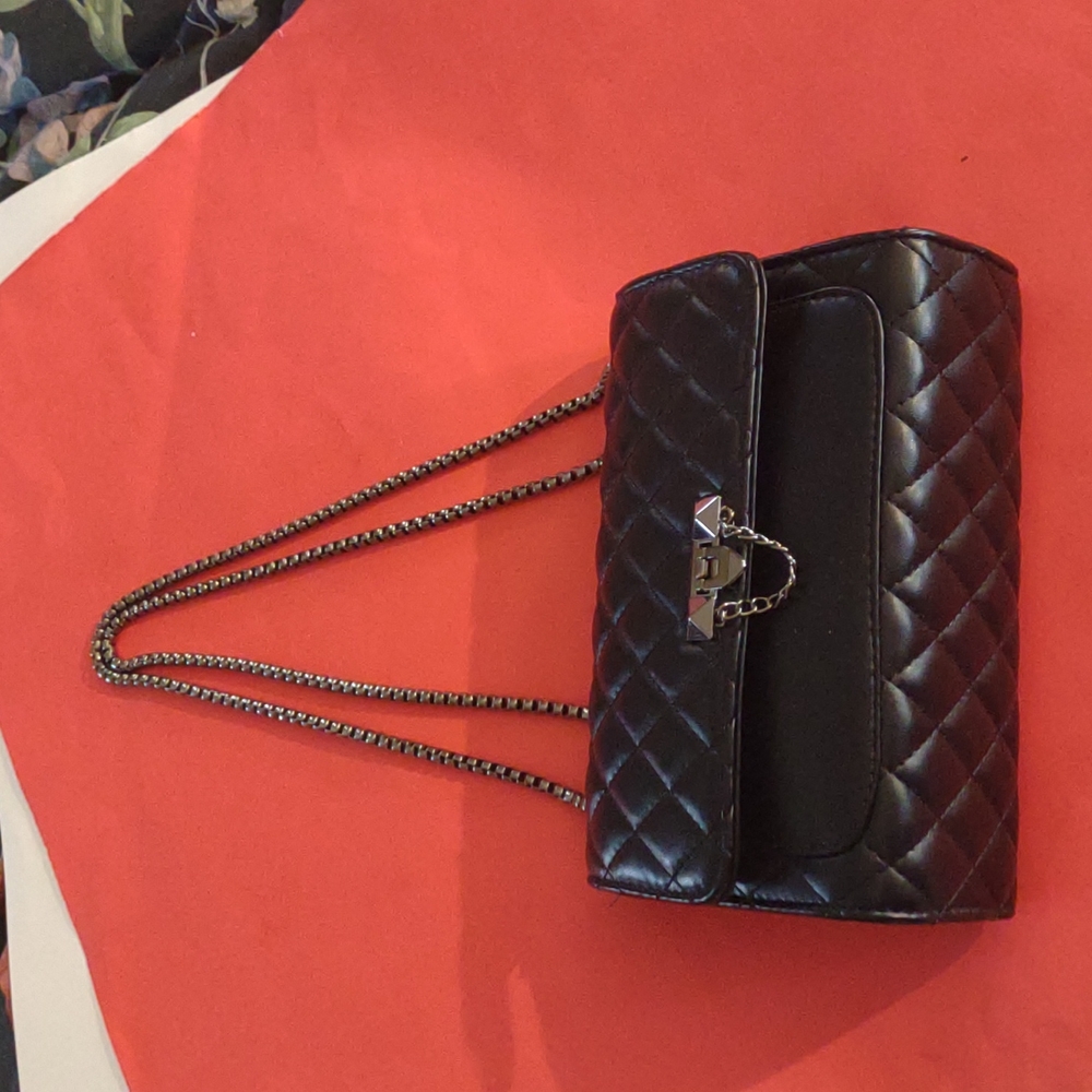 Black quilted evening bag with silver chain handle and metal fold over clasp